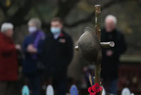 Andrew Milligan / PA Wire A helmet on a grave