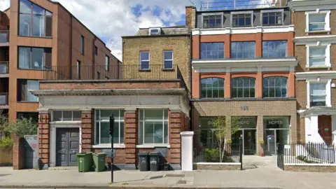 Exterior of the HCTPS office in London. It is a four storey red brick building with large windows and the HCTPS name above the main entrance