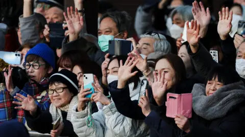 Reuters Voters hold up their phones and wave at a Sanae Takaichi campaign event in Japan