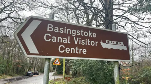 Clare Cowan Sign points to Basingstoke Canal Visitor Centre