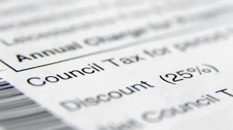 A council tax document lies on a surface. Words on the document have been blurred apart from the words 'council tax' and information on a discount.