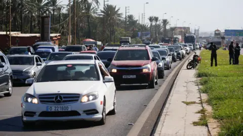 Reuters Cars are stuck in a traffic jam on a road from the southern Lebanese city of Sidon, amid heavy Israeli air strikes (September 23, 2024)