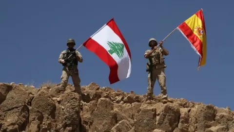 lebarmy.gov.lb Handout from the Lebanese army shows troops waving both the Lebanese and Spanish flags in the territory of Ras Baalbek