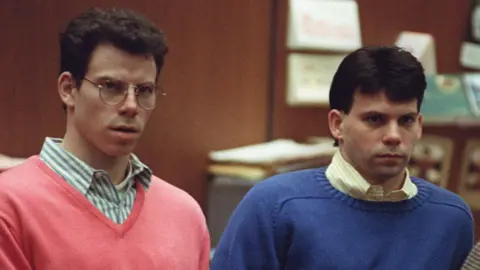 Erik and Lyle Menendez during one of their criminal trials in the 1990s. They are wearing colourful jumpers and smart shirts as they observe proceedings