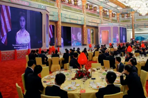 AFP/Getty Images Guest watch a video of Arabella Kushner, granddaughter of US President Donald Trump, sing a traditional Chinese song during a state dinner at the Great Hall of the People in Beijing on 9 November 2017