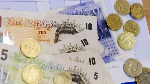 PA Media Notes and coins on a payslip