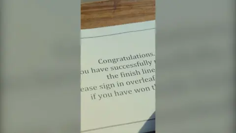 The sign-in book with the message 'Congratulations. You have successfully reached the finish line. Please sign in overleaf to find out if you have won the race.'