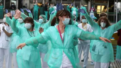 EPA Health workers react during the nightly applause at eight o'clock at 12 de Octubre hospital