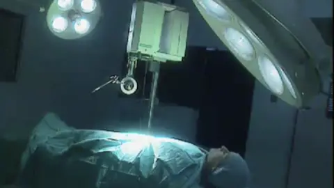 A robot is operating on a patient on a hospital bed