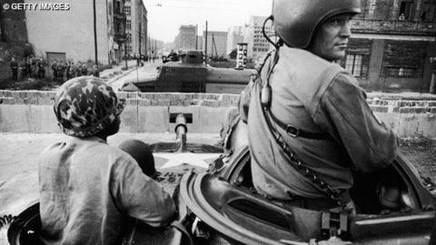 Soldiers looking over the Berlin Wall