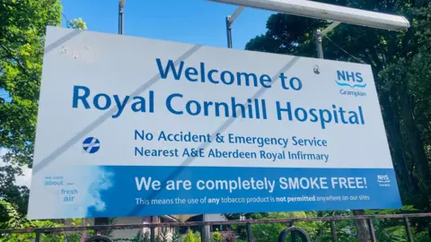 BBC A sign which says 'Welcome to Royal Cornhill Hospital'.
