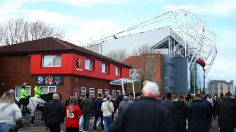 Reuters Manchester United fans walk to Old Trafford as mounted police watch on outside the football club.