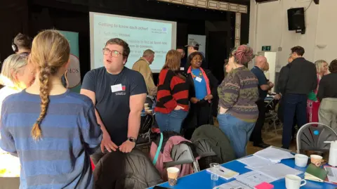 A group of people stand around talking