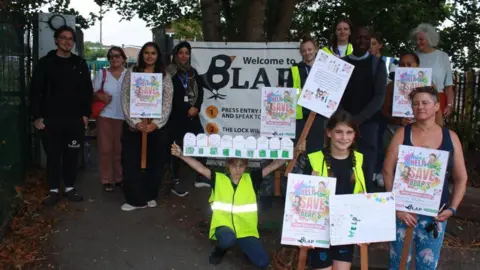 Campaigners raising awareness for the playground holding signs.