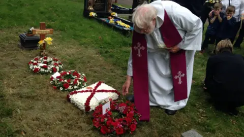 Father Derek Hailes at Frank Le Villio's grave