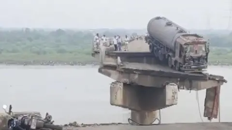 ANI A truck stuck at the precipice of a collapsed bridge in Gujarat