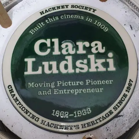 Rio Cinema Green plaque with white writing which reads CLARA LUDSKI, Moving picture pioneer, 1862-1933, Built this cinema in 1909