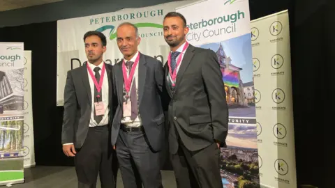 Shariqua Ahmed/BBC Mohammed Farooq looking happy with his two sons on election night 