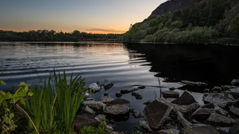 Steph Virot A sunset over a loch, with the water clearly rippling.