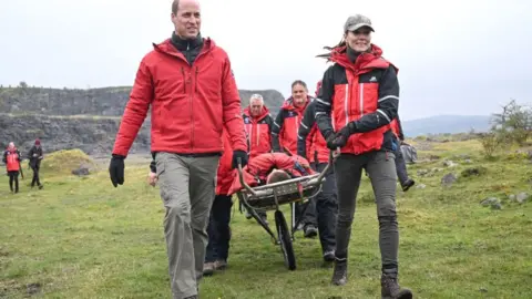 Getty Images Britain's Prince William, Prince of Wales and Britain's Catherine, Princess of Wales take part in medical support exercises during a visit to the Central Beacons Mountain Rescue Team as part of a tour in Wales, on April 27, 2023. (Photo by Matthew Horwood / POOL / AFP) (Photo by MATTHEW HORWOOD/POOL/AFP via Getty Images)