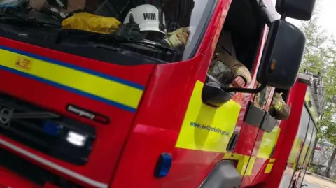 West Yorkshire Fire Service Image showing fire engines with firefighter in the cabin