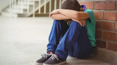 Getty Images Boy with his head in his hands