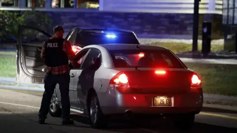 EPA Police car with brake lights on, officer in vest that says "Police".