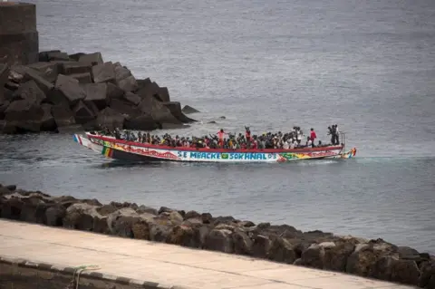 ANTONIA SEMPERE / AFP Migran Afrika, bagian dari kelompok 242 migran di atas dua perahu, tiba di atas perahu di pelabuhan La Restinga di pulau Canary El Hierro.