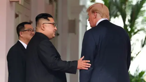 Getty Images North Korea's leader Kim Jong Un (C) gestures as he meets with US President Donald Trump (R)