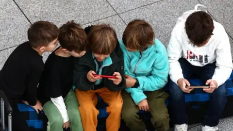 Anna Szilagyi/EPA-EFE/REX/Shuttershock Children using smartphones