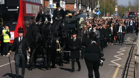 Getty Images Mourners followed a horse-drawn carriage before Tom Parker's funeral