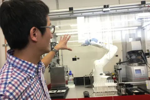 Chingyao Yang shows off one of Just Inc.'s robots