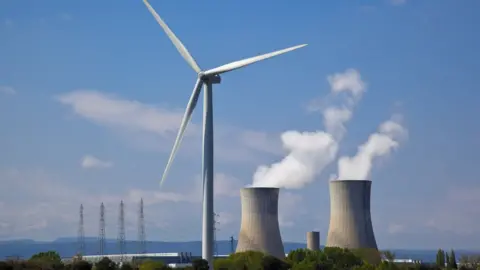 Getty Images Nuclear station and wind turbine