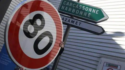 Getty Images An employee holds a 80km/h traffic sign at the factory of manufacturer Lacroix Signalisation in Saint-Herblain, a suburb of Nantes, on 8 February 2018