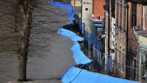 PA Media Temporary flood barriers which have been moved by the River Severn towards the Wharfage in Ironbridge