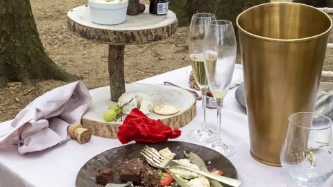 Ashley Cooper GWI Remains of half eaten food and champagne cork and glasses