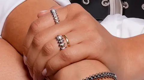 Getty Images A close-up of the above photo showing Zendaya's hand showing a gold band and another ring on her wedding finger