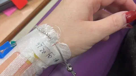 Gemma Doherty A woman's hand with an IV in. 