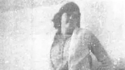 A black and white pixelated picture of a young woman with short dark hair. Only her outline can be made out. 