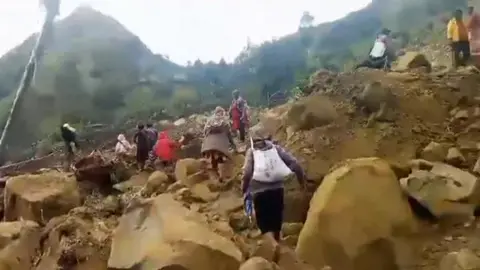 People scramble over rubble after landslide