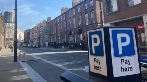 A 'pay here' sign in a street in Liverpool city centre.