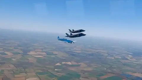 Aircraft from the Battle of Britain Memorial Flight take part in a commemorative flypast.