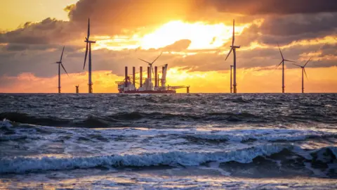 Getty Images looking out to sea where a ship is surrounded by offshore wind turbines