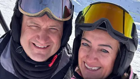 Family photo Nick and Pippa Bowkett wearing ski helmets