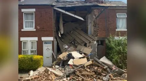 PA Media Masses of rubble in front of a house which was destroyed in an explosion