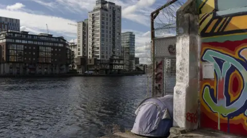 Getty Images A tent belonging to homeless people pitched at the edge of the water in the Silicon Docks area in central Dublin, Ireland