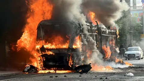 PA Media A glider bus is on fire on the Newtownards Road.