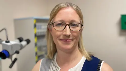 A woman with blond hair and glasses
