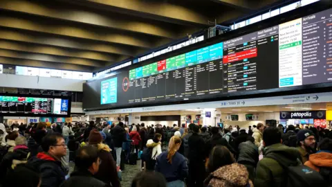 Euston station full of passengers looking at departure boards