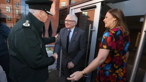 PA/Liam McBurney New PSNI Chief Constable Jon Boutcher is greeted by NI Policing Board vice-chair Edgar Jardine